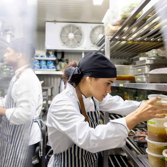 Cooks working at a restaurant and looking for ingredients in the pantry Latin American cooks working at a restaurant and looking for ingredients in the pantry